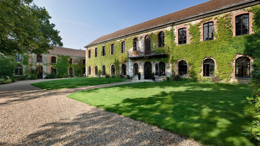 Chateau Perche building with green front lawn and patio