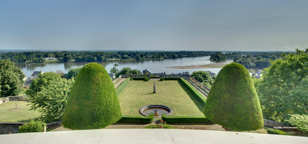Chateau in Loire shape cut trees and courtyard with view over lake
